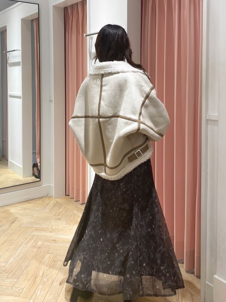 ベージュ系のムートンコート、ブラック系のブーツ、ホワイト系のニット/セーターを着用したレディースの秋コーディネートの8枚目の写真