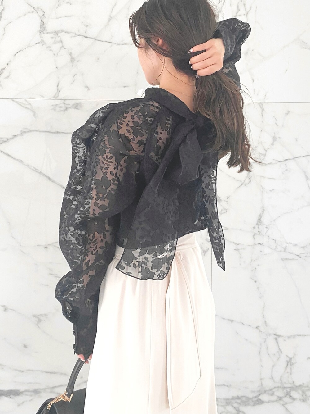 ブラック系のシャツ/ブラウス、ホワイト系のスカート、ブラック系のブーツを着用したレディースの冬コーディネートの5枚目の写真