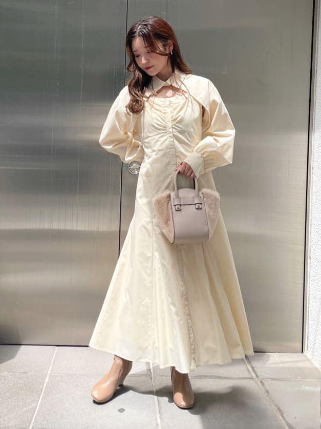 ベージュ系のブーツ、ホワイト系のハンドバッグ、ホワイト系のワンピースを着用したレディースの秋コーディネートの3枚目の写真