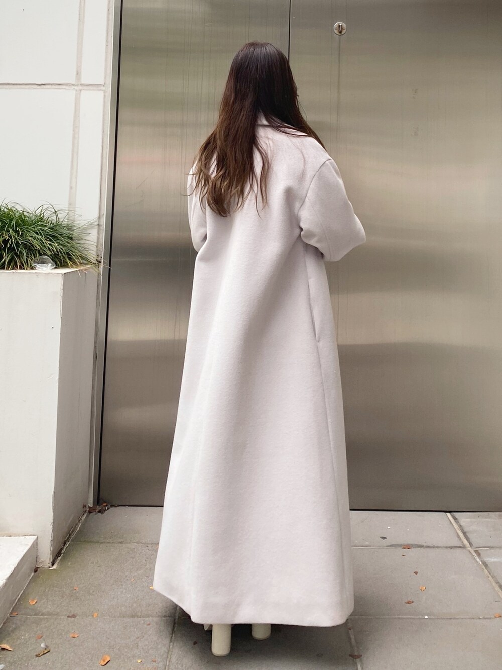 ホワイト系のニット/セーター、ベージュ系のスカート、ホワイト系のブーツを着用したレディースの秋コーディネートの4枚目の写真