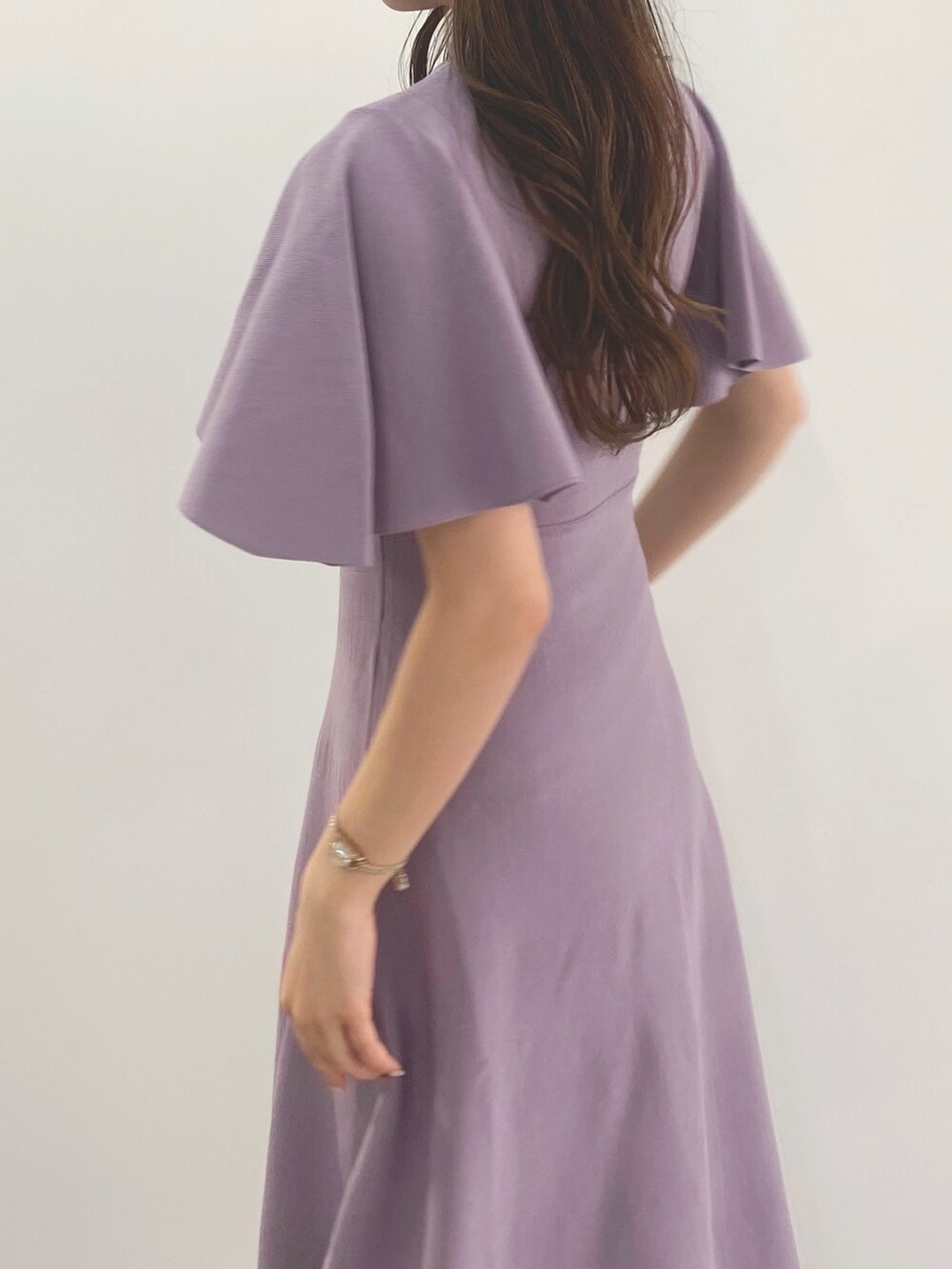 ホワイト系のサンダル、パープル系のワンピースを着用したレディースの冬コーディネートの5枚目の写真