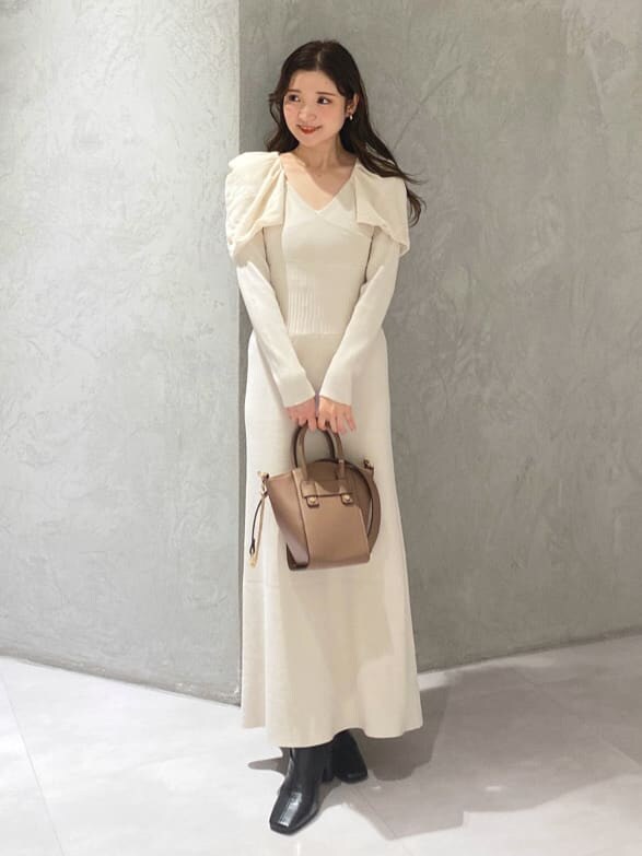 ブラック系のブーツ、ブラウン系のハンドバッグ、ホワイト系のワンピースを着用したレディースの秋コーディネートの2枚目の写真