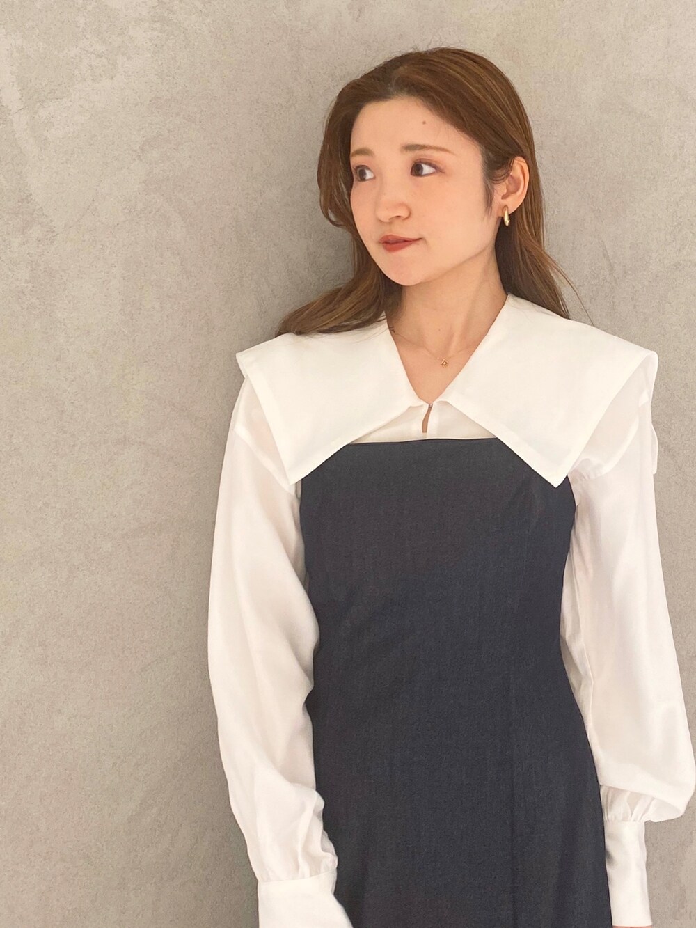 ホワイト系のブーツ、ブルー系のワンピース、ホワイト系のハンドバッグを着用したレディースの冬コーディネートの4枚目の写真