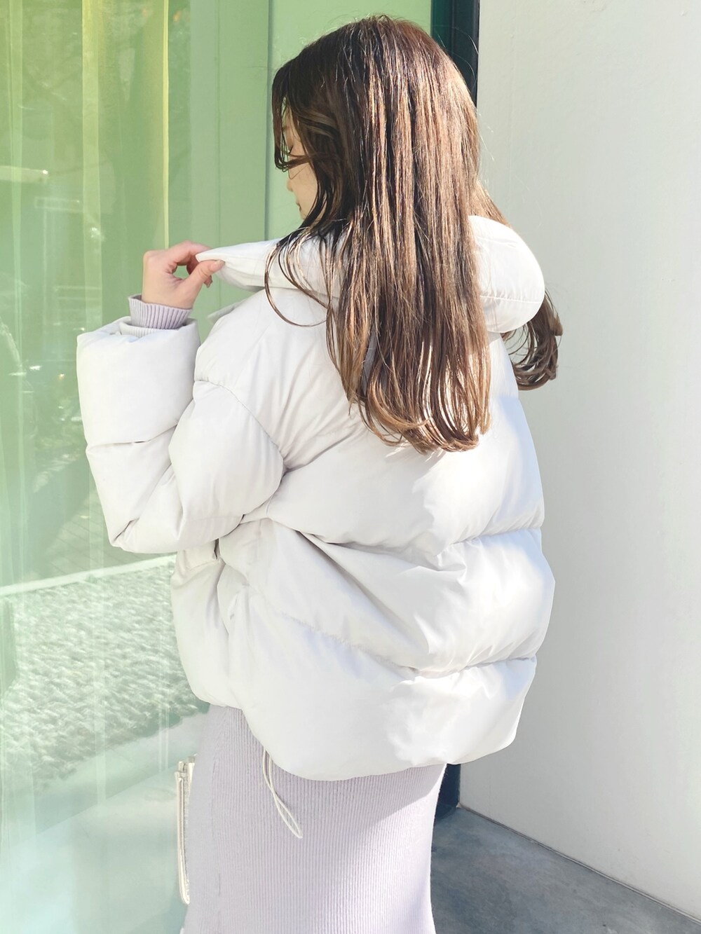 ピンク系のワンピース、ホワイト系のショルダーバッグ、ホワイト系のブーツを着用したレディースの冬コーディネートの4枚目の写真