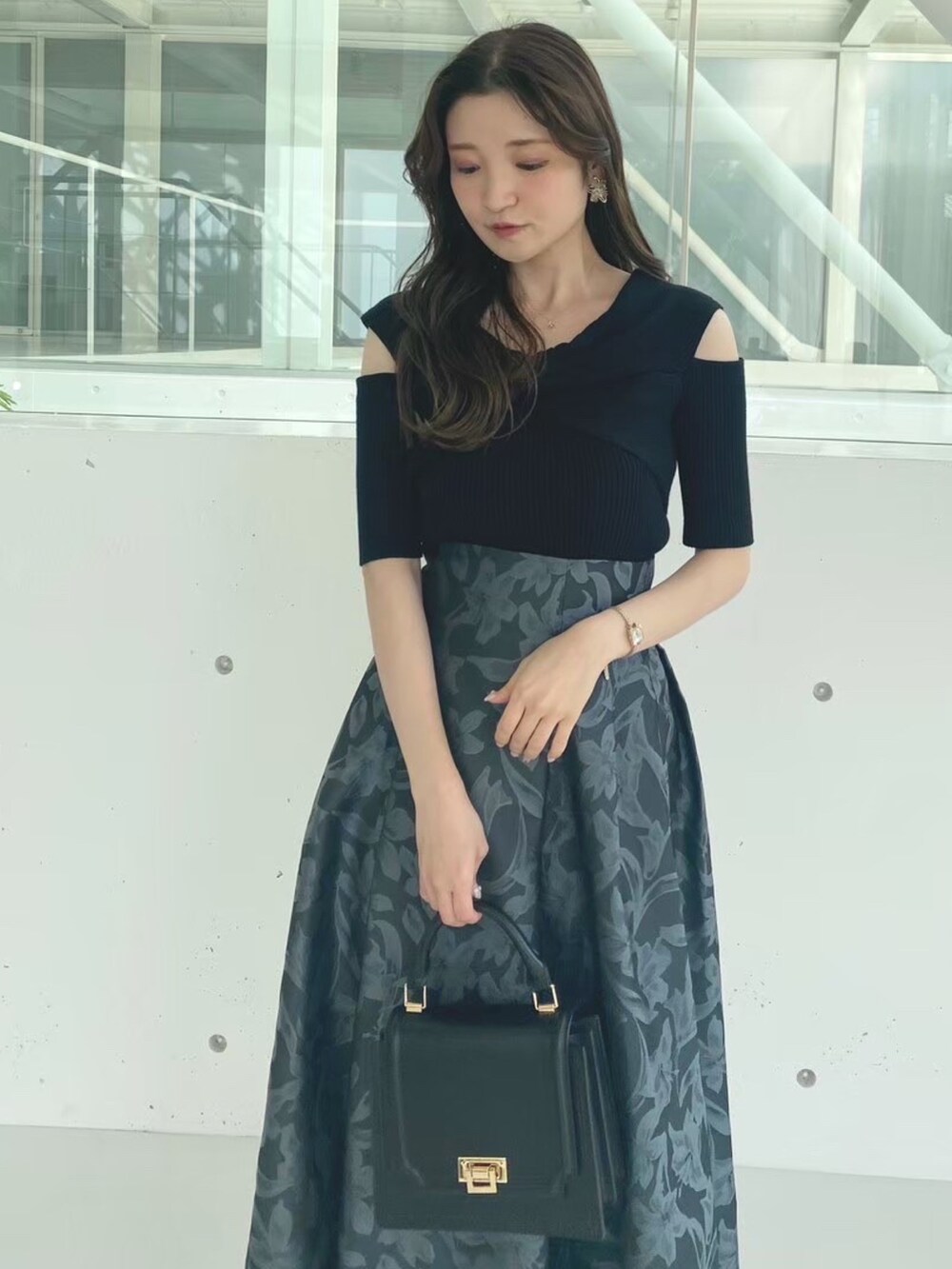 ブラック系のハンドバッグ、ブラック系のブーツ、ブラック系のニット/セーターを着用したレディースの秋コーディネートの5枚目の写真