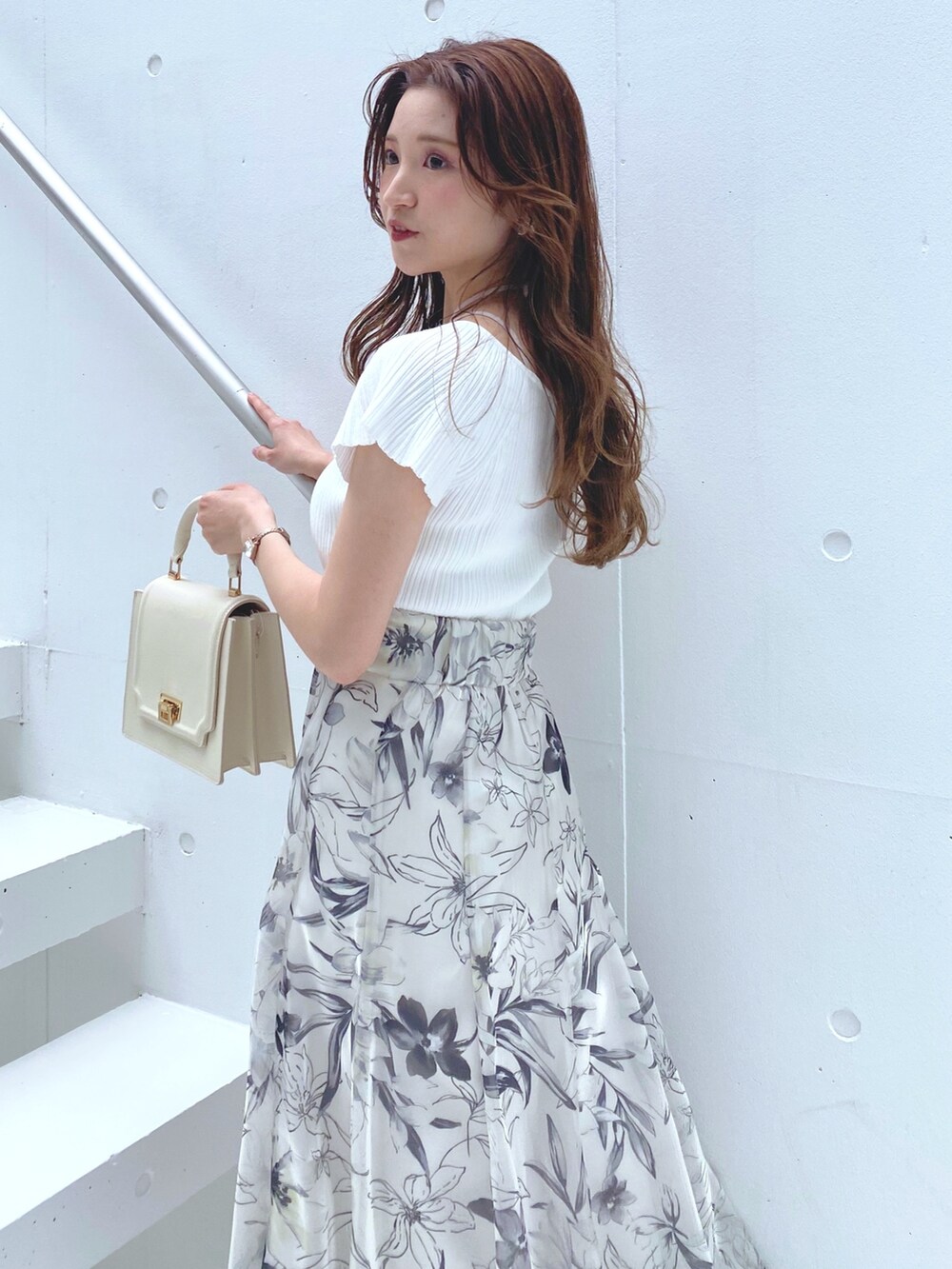 ホワイト系のニット/セーター、ブラウン系のサンダル、ホワイト系のハンドバッグを着用したレディースの夏コーディネートの3枚目の写真