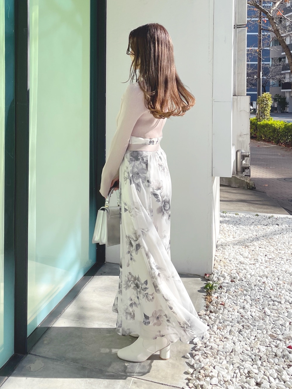 ベージュ系のワンピース、ホワイト系のブーツ、シルバー系のハンドバッグを着用したレディースの冬コーディネートの7枚目の写真