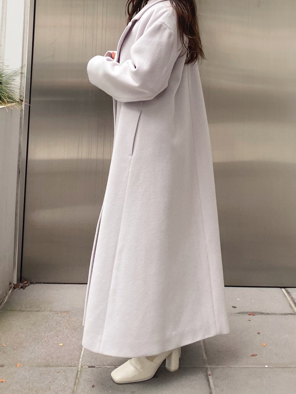 ホワイト系のニット/セーター、ベージュ系のスカート、ホワイト系のブーツを着用したレディースの秋コーディネートの3枚目の写真