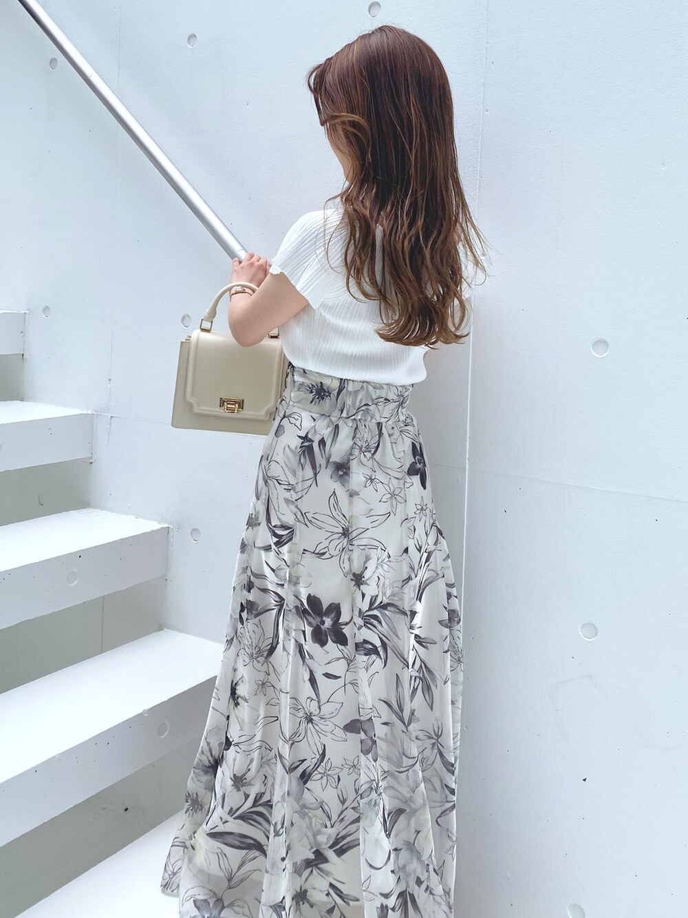ホワイト系のニット/セーター、ブラウン系のサンダル、ホワイト系のハンドバッグを着用したレディースの夏コーディネートの4枚目の写真