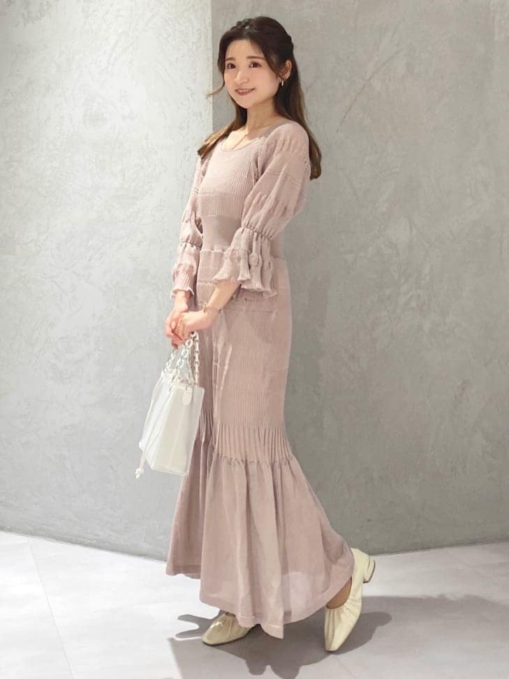 ベージュ系のワンピース、ホワイト系のハンドバッグ、ホワイト系のパンプスを着用したレディースの冬コーディネートの9枚目の写真