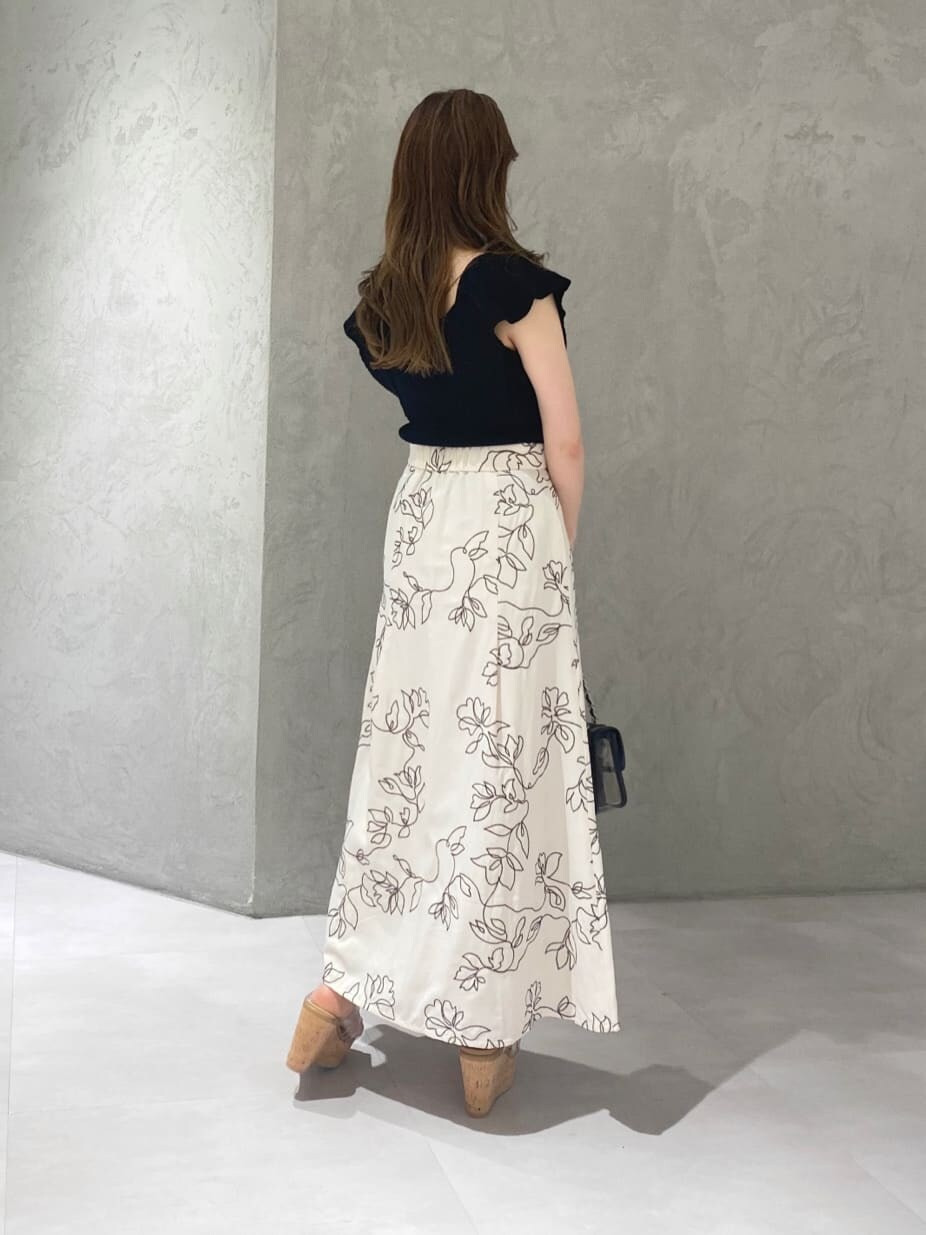 ブラック系のショルダーバッグ、ブラック系のニット/セーター、ホワイト系のスカートを着用したレディースの夏コーディネートの7枚目の写真