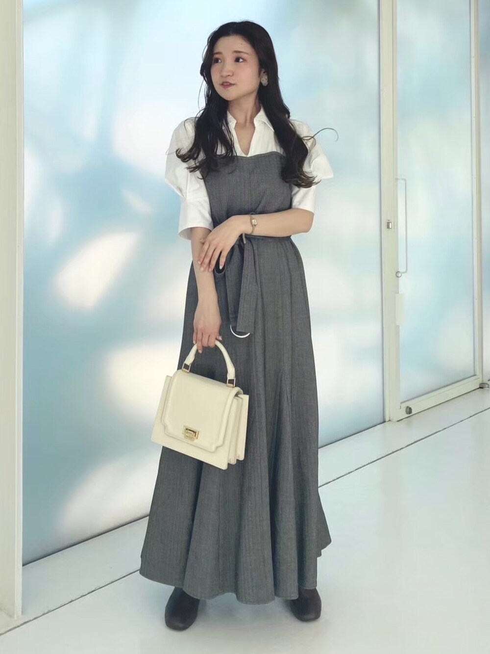 ホワイト系のハンドバッグ、その他のワンピース、ブラウン系のブーツを着用したレディースの秋コーディネートの3枚目の写真