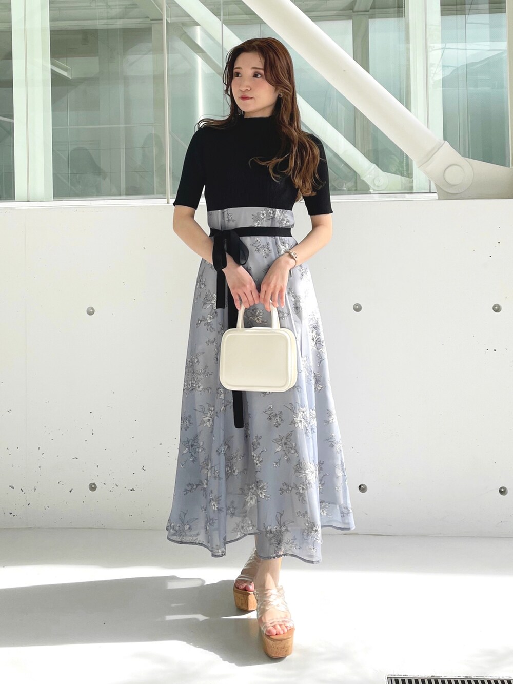 ホワイト系のサンダル、ホワイト系のハンドバッグ、グレー系のワンピースを着用したレディースの冬コーディネートの2枚目の写真