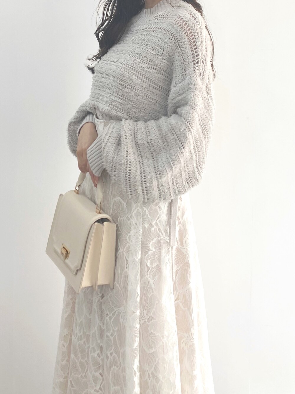 ホワイト系のサンダル、グレー系のニット/セーター、ホワイト系のハンドバッグを着用したレディースの冬コーディネートの6枚目の写真