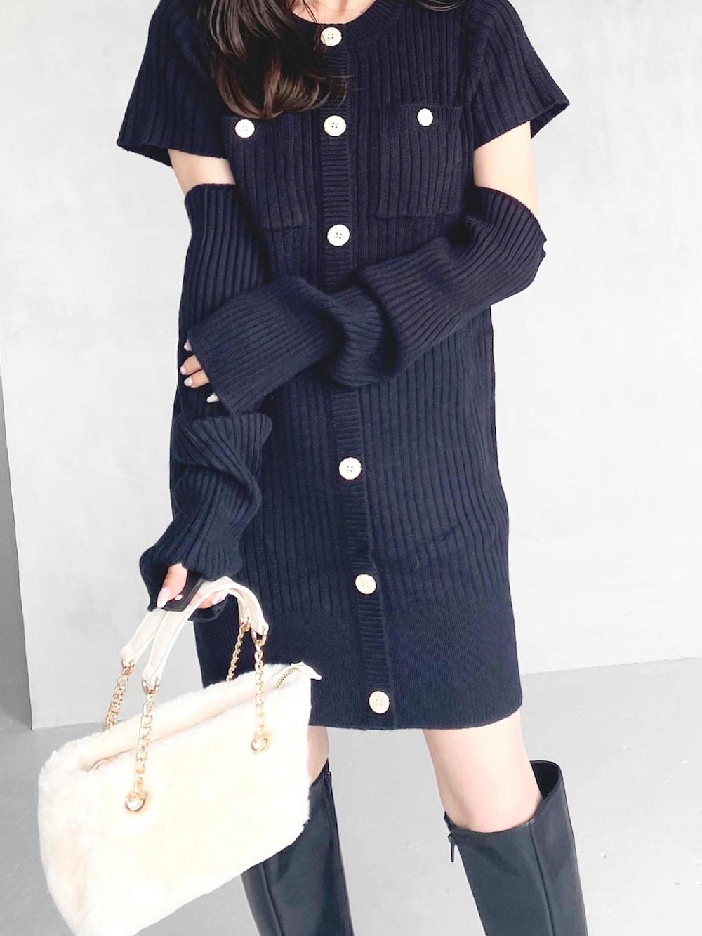 ブラック系のワンピース、ブラック系のブーツ、ホワイト系のハンドバッグを着用したレディースの秋コーディネートの6枚目の写真