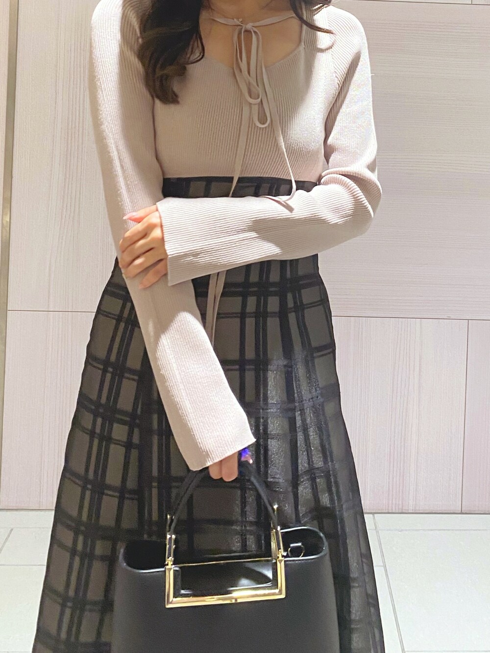 ピンク系のワンピース、ブラック系のハンドバッグ、ホワイト系のブーツを着用したレディースの秋コーディネートの7枚目の写真