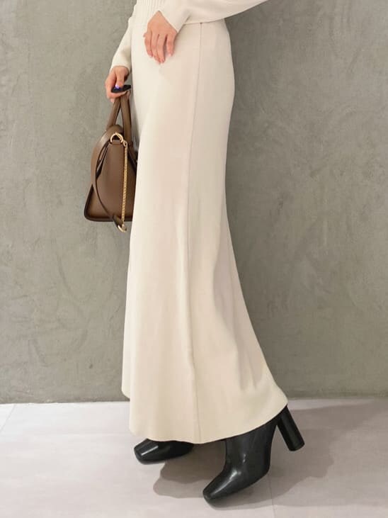 ブラック系のブーツ、ブラウン系のハンドバッグ、ホワイト系のワンピースを着用したレディースの秋コーディネートの8枚目の写真