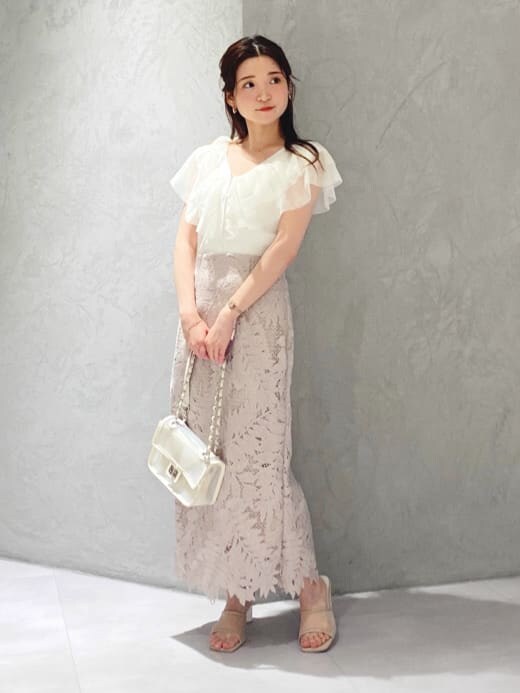 ピンク系のスカート、ベージュ系のサンダル、ホワイト系のカーディガン/ボレロを着用したレディースの夏コーディネートの2枚目の写真