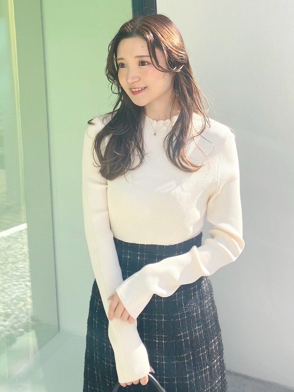 ホワイト系のブーツ、ブラック系のハンドバッグ、ブラック系のワンピースを着用したレディースの冬コーディネートの4枚目の写真