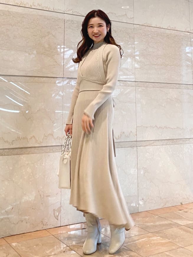 ベージュ系のワンピース、ホワイト系のハンドバッグを着用したレディースの冬コーディネートの2枚目の写真