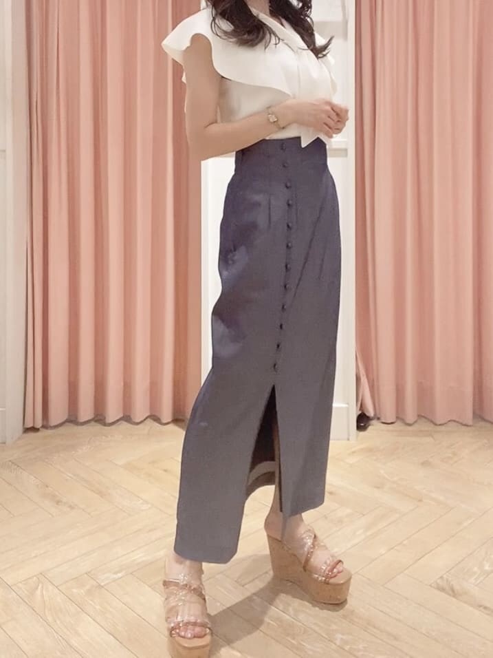 ホワイト系のニット/セーター、ブルー系のスカート、ベージュ系のサンダルを着用したレディースの夏コーディネートの2枚目の写真