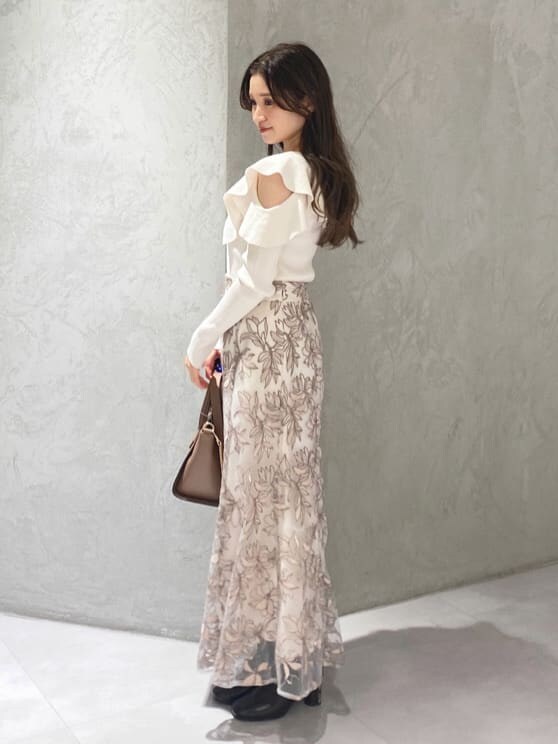 ブラウン系のハンドバッグ、ホワイト系のニット/セーター、ピンク系のスカートを着用したレディースの秋コーディネートの4枚目の写真