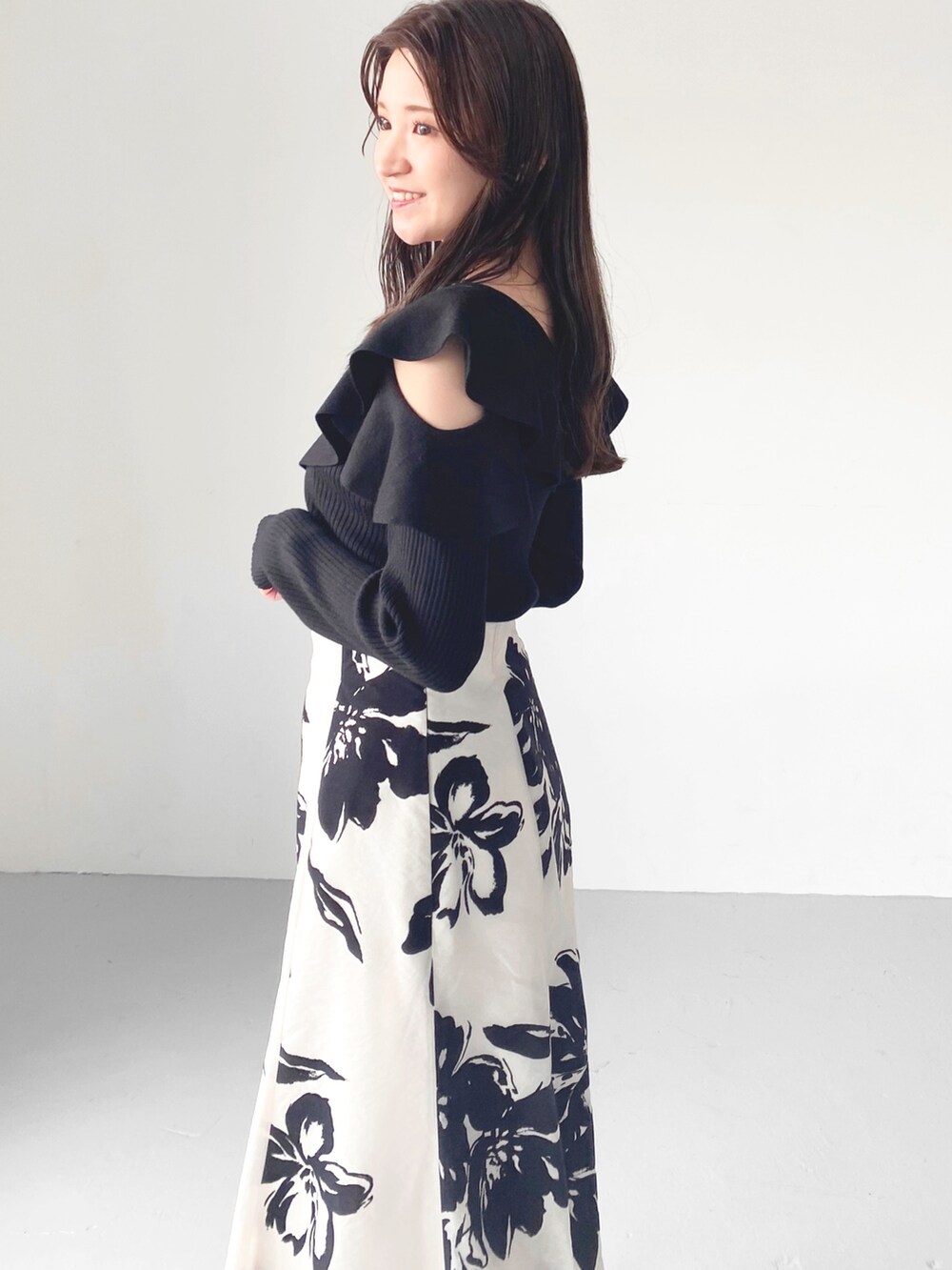 ブラック系のブーツ、ホワイト系のスカート、ブラック系のニット/セーターを着用したレディースの秋コーディネートの5枚目の写真