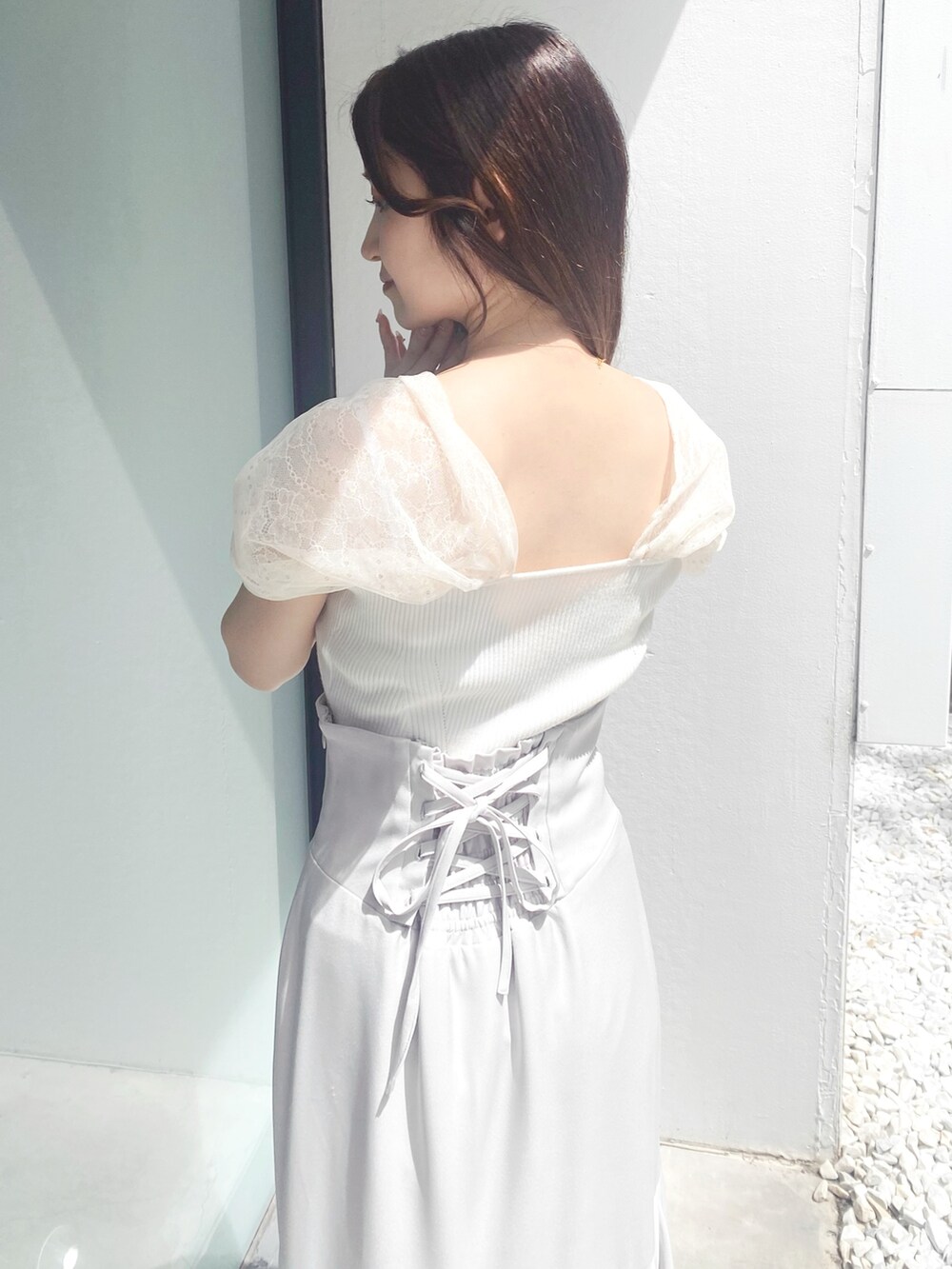 グレー系のスカート、ホワイト系のサンダル、ホワイト系のニット/セーターを着用したレディースの夏コーディネートの6枚目の写真