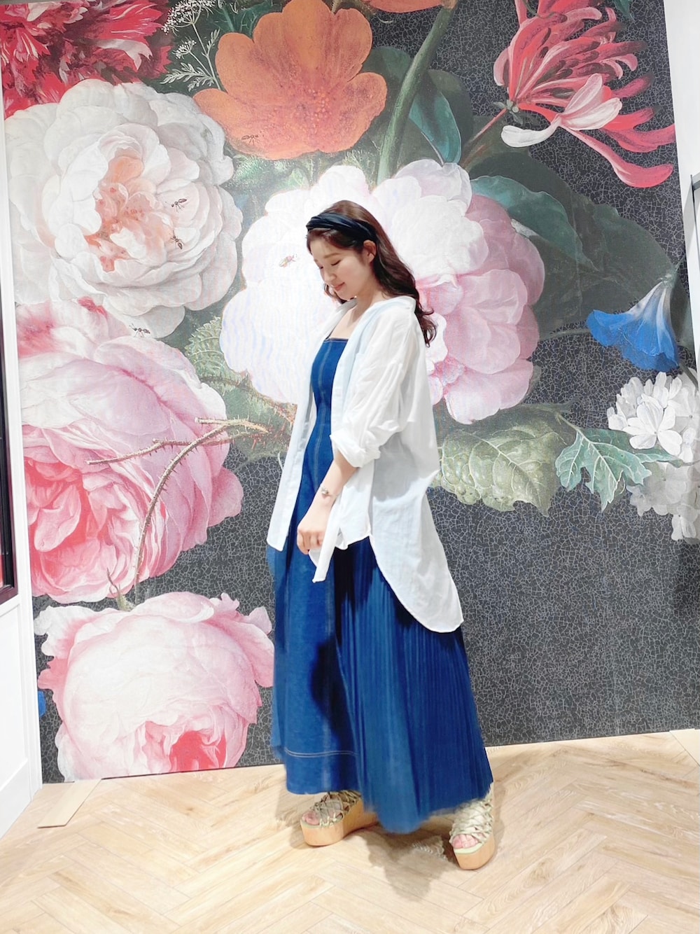 ブルー系のワンピース、ホワイト系のシャツ/ブラウス、ブラウン系のサンダルを着用したレディースの春コーディネートの3枚目の写真