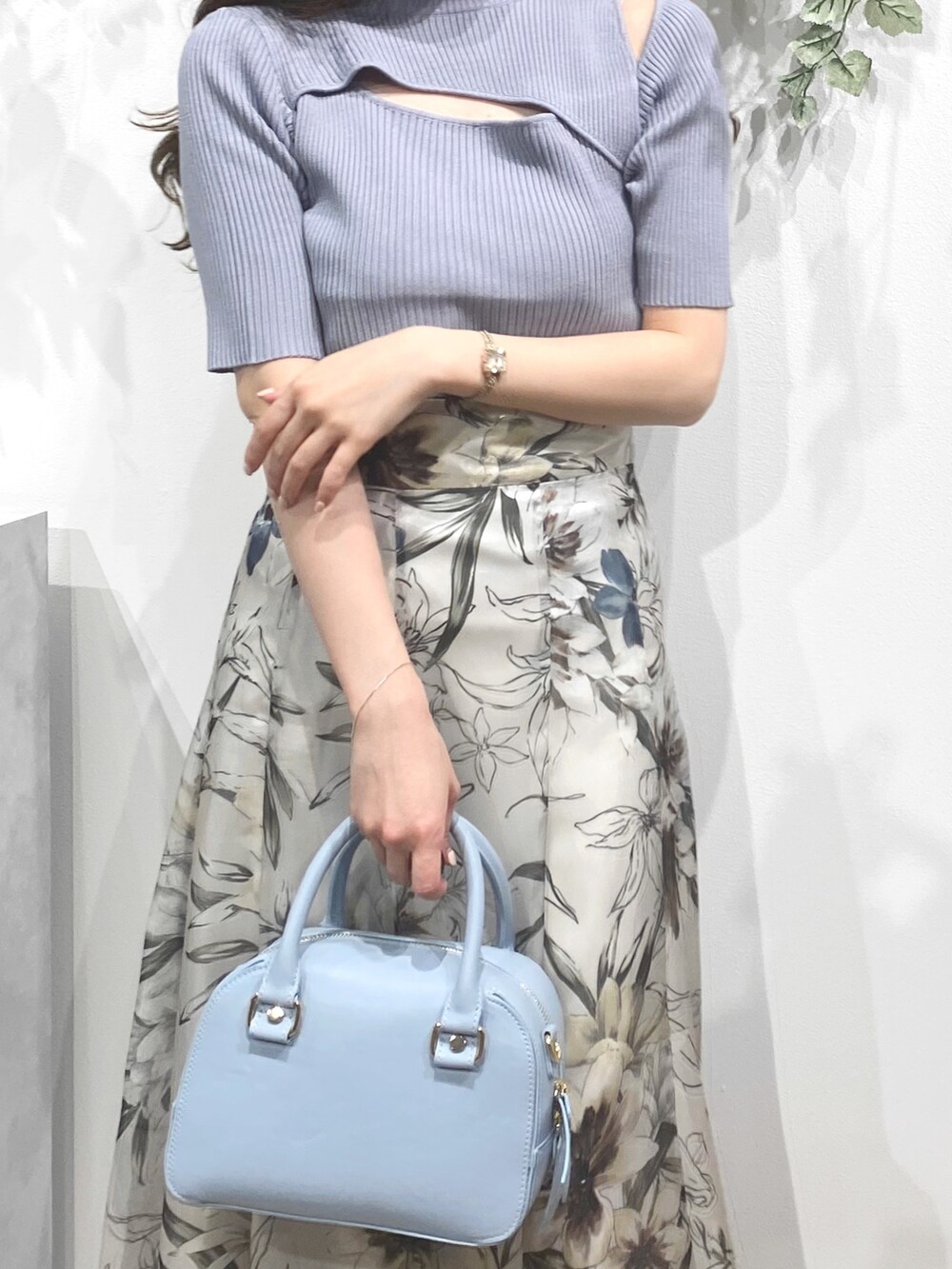 ホワイト系のサンダル、ブルー系のボストンバッグ、グリーン系のスカートを着用したレディースの春コーディネートの7枚目の写真