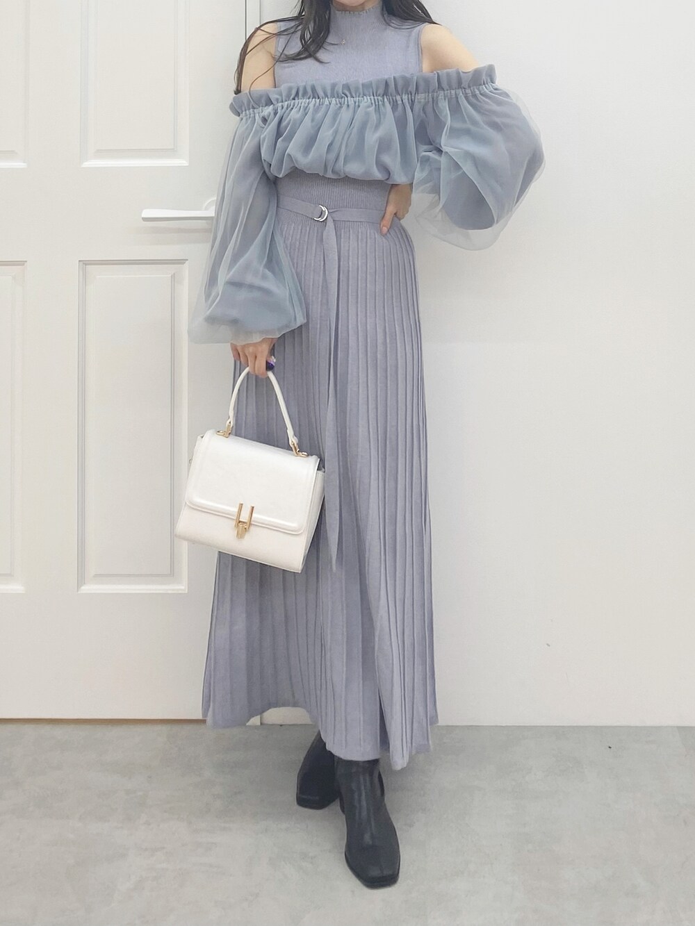 ブラック系のブーツ、ホワイト系のハンドバッグ、ブルー系のワンピースを着用したレディースの秋コーディネートの3枚目の写真