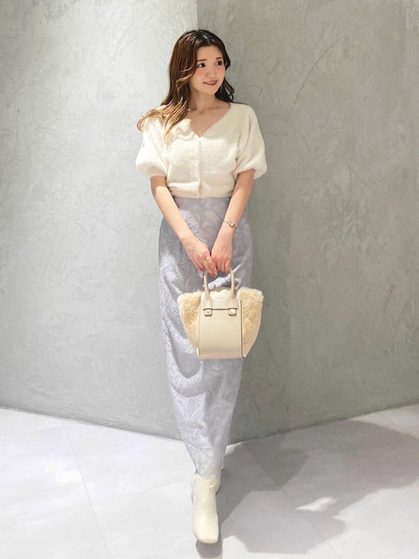 ホワイト系のカーディガン/ボレロ、ホワイト系のブーツ、グレー系のスカートを着用したレディースの夏コーディネートの2枚目の写真