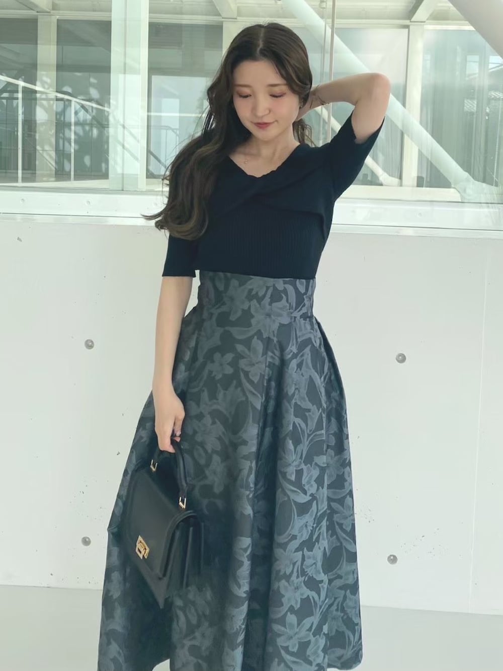 ブラック系のハンドバッグ、ブラック系のブーツ、ブラック系のニット/セーターを着用したレディースの秋コーディネートの4枚目の写真