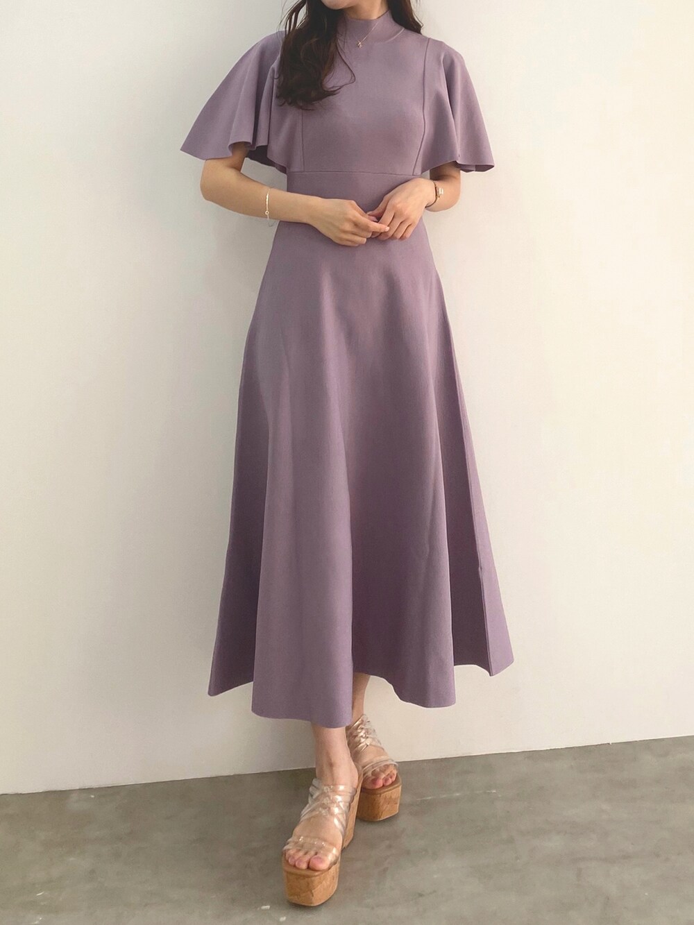 ホワイト系のサンダル、パープル系のワンピースを着用したレディースの冬コーディネートの3枚目の写真