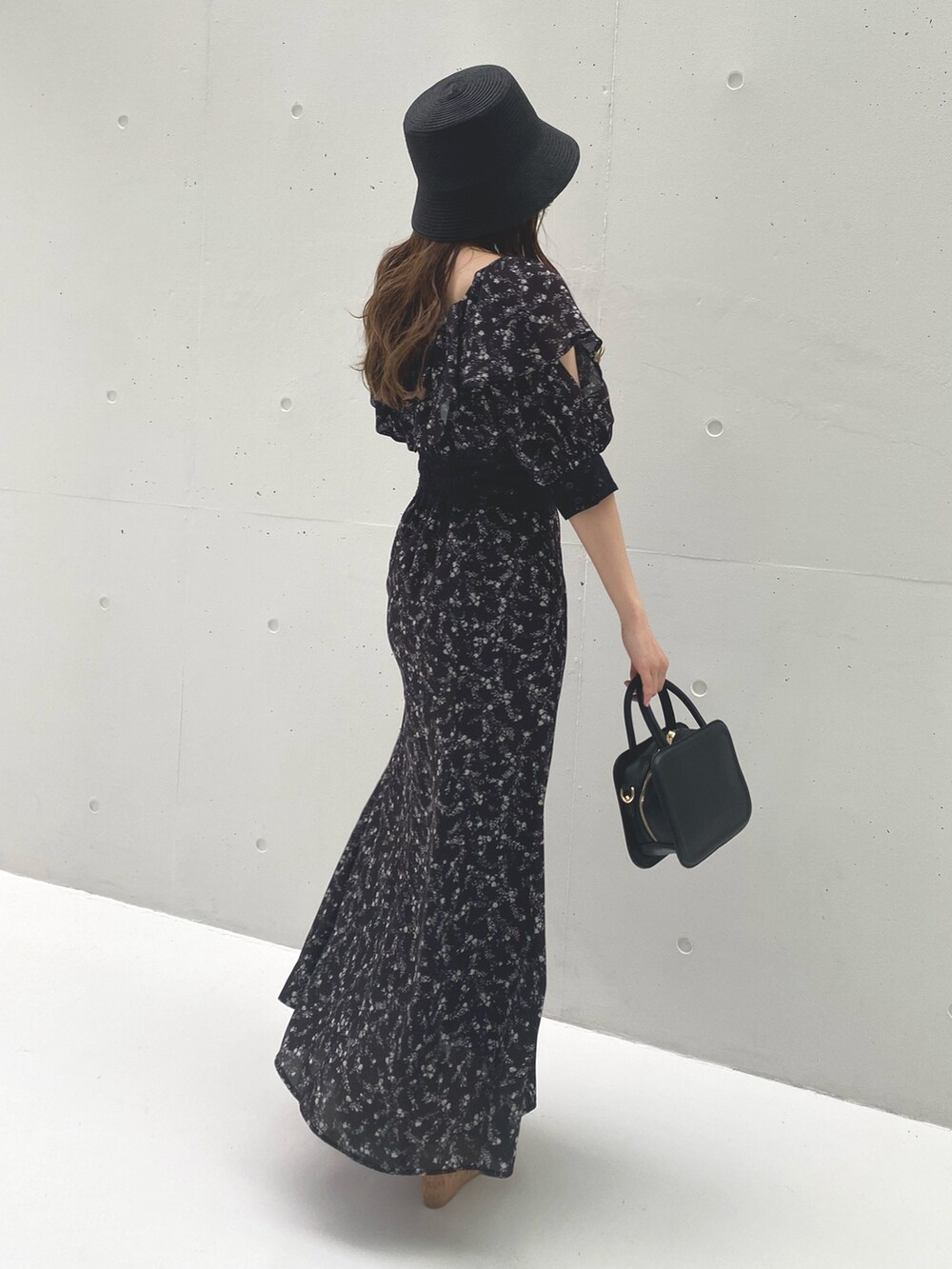ブラック系のワンピース、その他のサンダル、ブラック系のハンドバッグを着用したレディースの夏コーディネートの6枚目の写真