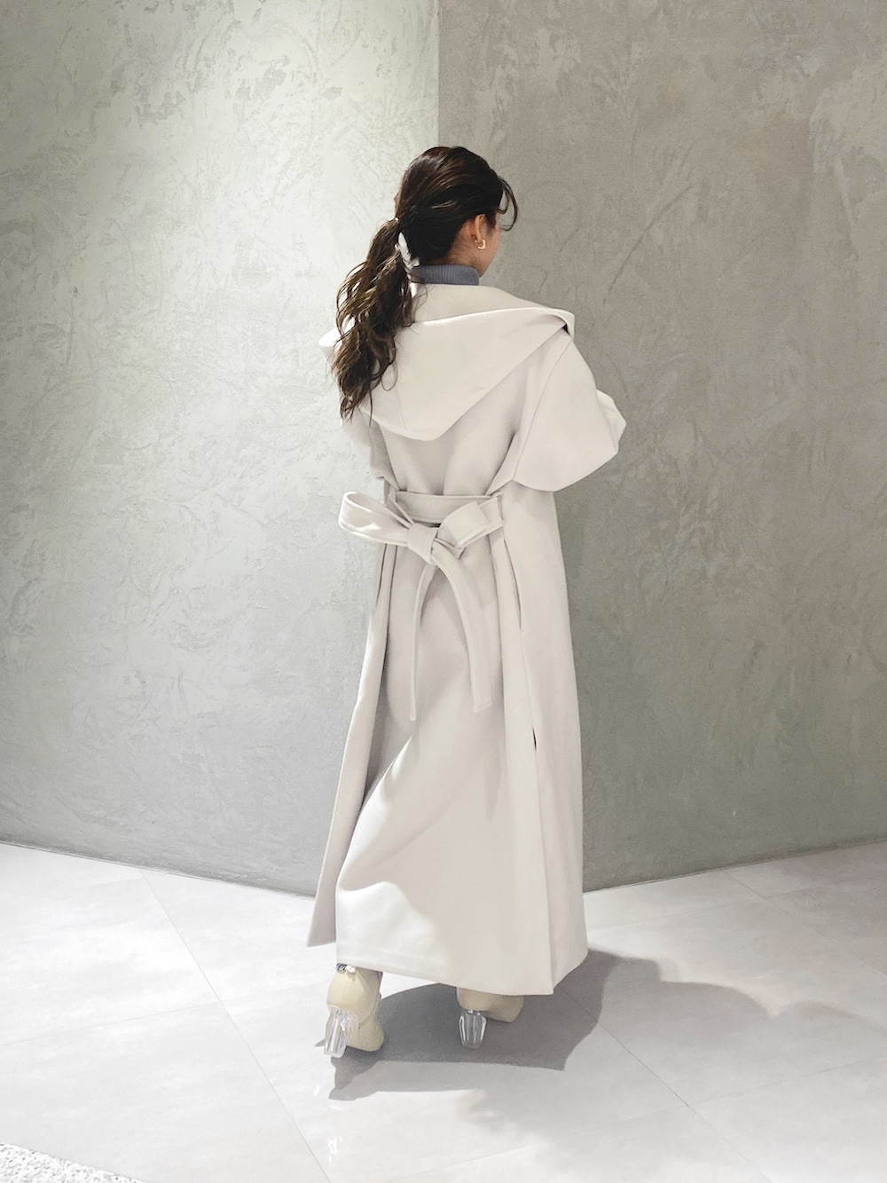 ホワイト系のスカート、ブルー系のニット/セーター、ホワイト系のチェスターコートを着用したレディースの冬コーディネートの10枚目の写真