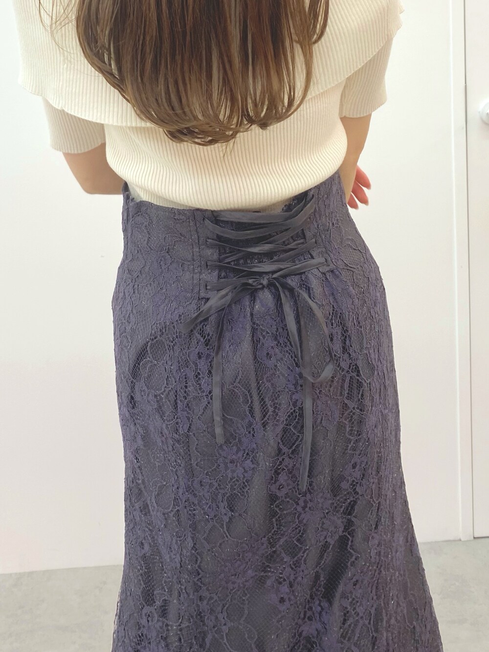 ホワイト系のニット/セーター、ブラック系のブーツ、グレー系のスカートを着用したレディースの秋コーディネートの6枚目の写真