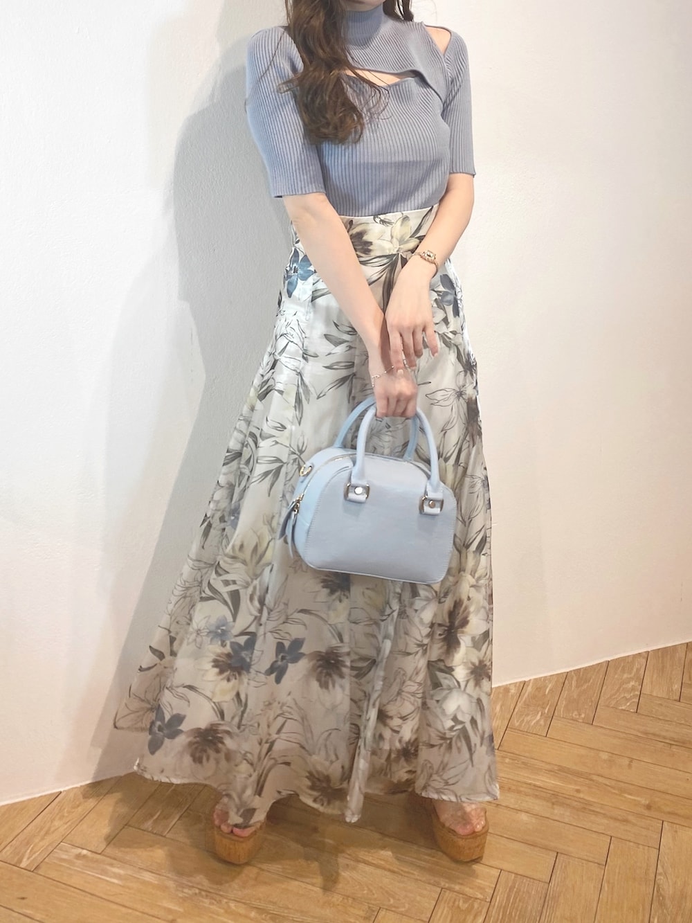 ホワイト系のサンダル、ブルー系のボストンバッグ、グリーン系のスカートを着用したレディースの春コーディネートの2枚目の写真