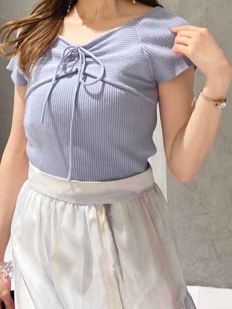 ピンク系のスカート、ブルー系のニット/セーター、ベージュ系のサンダルを着用したレディースの春コーディネートの4枚目の写真