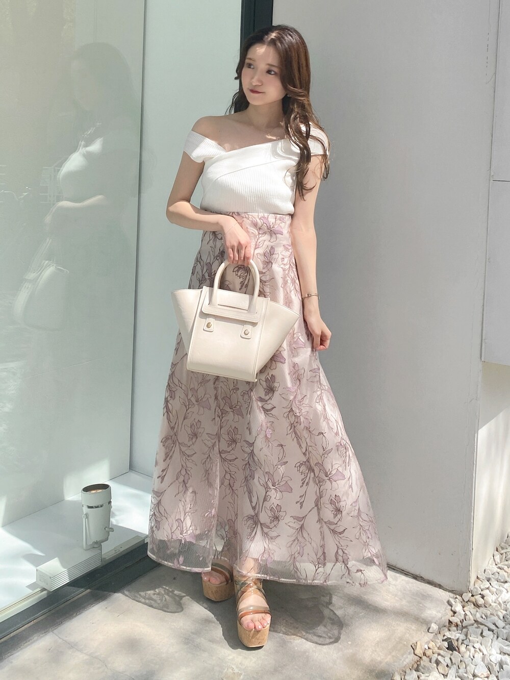 ピンク系のスカート、その他のサンダル、ホワイト系のニット/セーターを着用したレディースの夏コーディネートの2枚目の写真