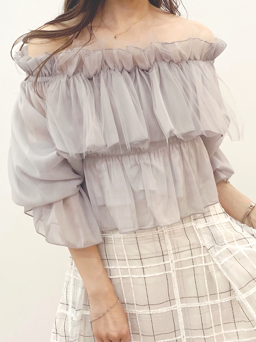 ホワイト系のハンドバッグ、ホワイト系のスカート、ブラック系のブーツを着用したレディースの夏コーディネートの5枚目の写真