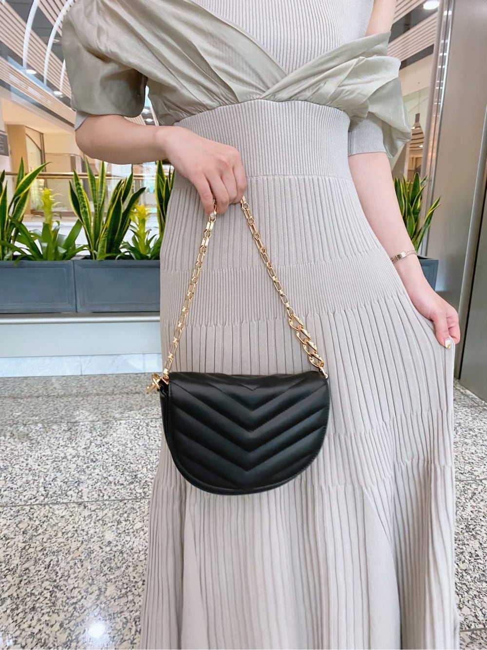 グリーン系のワンピース、ホワイト系のその他シューズ、ブラック系のハンドバッグを着用したレディースの夏コーディネートの4枚目の写真