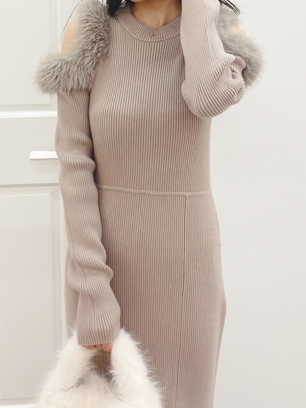 ホワイト系のハンドバッグ、ブラック系のブーツ、ベージュ系のワンピースを着用したレディースの秋コーディネートの4枚目の写真