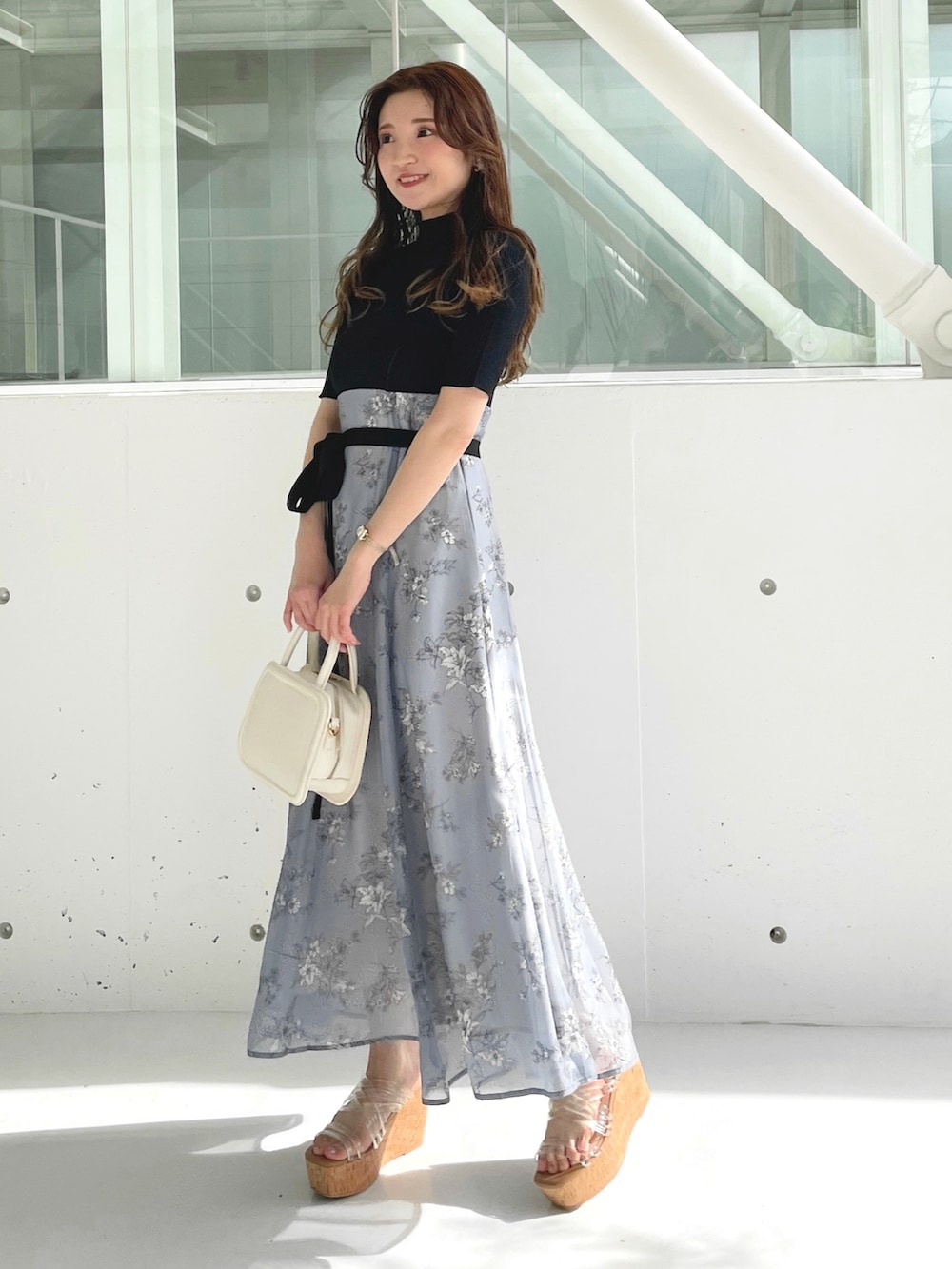 ホワイト系のサンダル、ホワイト系のハンドバッグ、グレー系のワンピースを着用したレディースの冬コーディネートの3枚目の写真