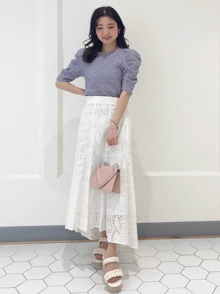 ホワイト系のスカート、パープル系のTシャツ/カットソー、ホワイト系のサンダルを着用したレディースの春コーディネートの2枚目の写真