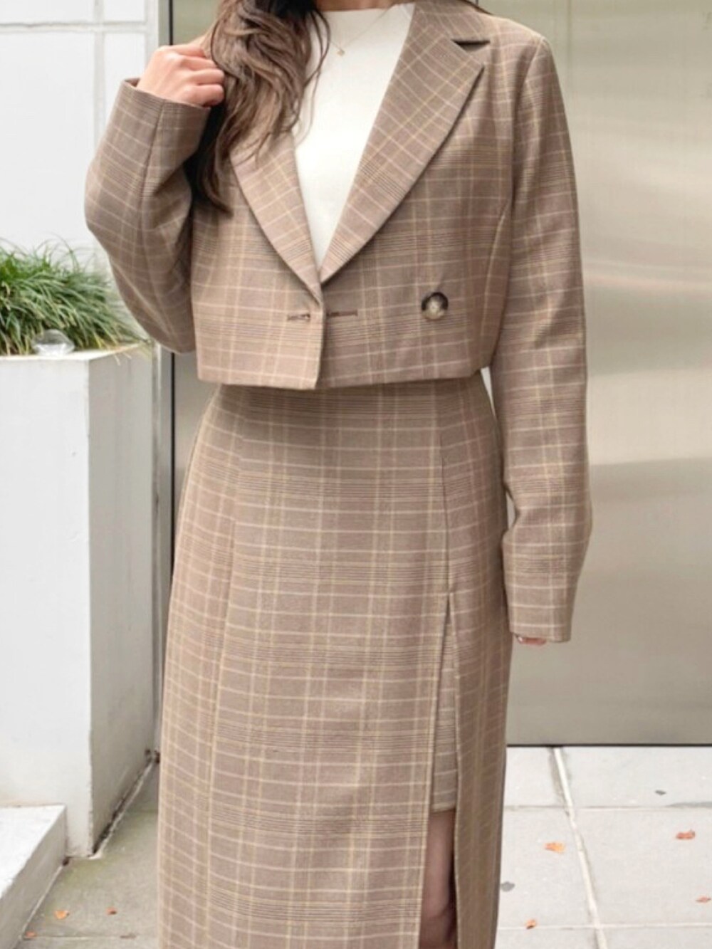 ベージュ系のテーラードジャケット、ベージュ系のスカート、ホワイト系のブーツを着用したレディースの秋コーディネートの5枚目の写真