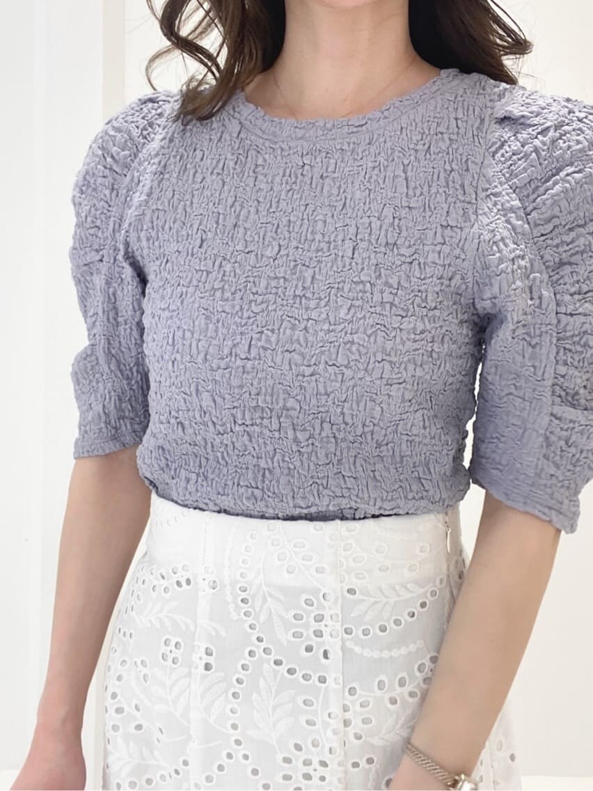 ホワイト系のスカート、パープル系のTシャツ/カットソー、ホワイト系のサンダルを着用したレディースの春コーディネートの4枚目の写真