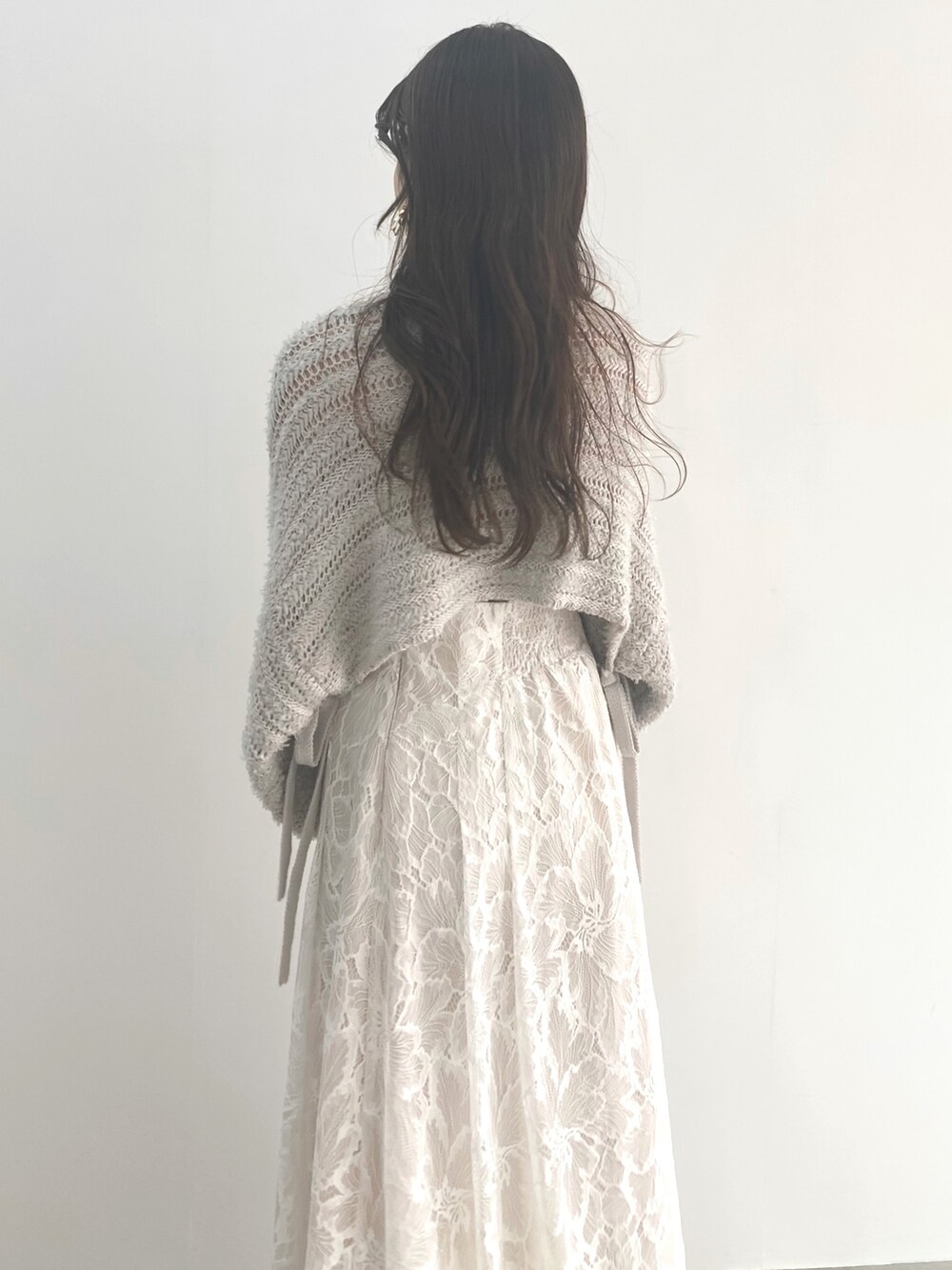 ホワイト系のサンダル、グレー系のニット/セーター、ホワイト系のハンドバッグを着用したレディースの冬コーディネートの5枚目の写真