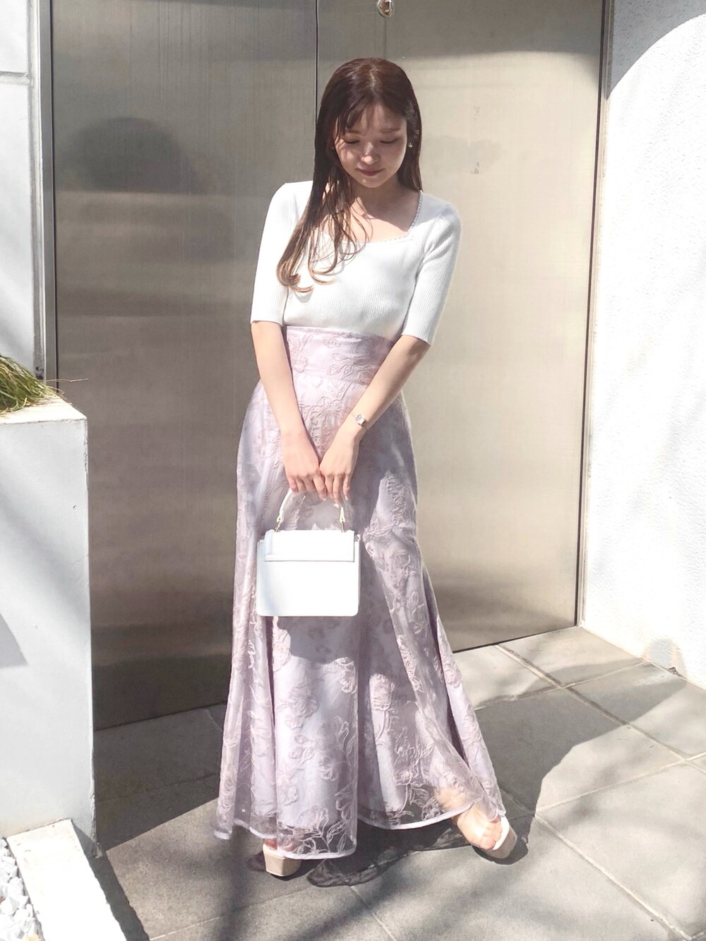 ホワイト系のニット/セーター、パープル系のスカート、その他のサンダルを着用したレディースの春コーディネートの2枚目の写真