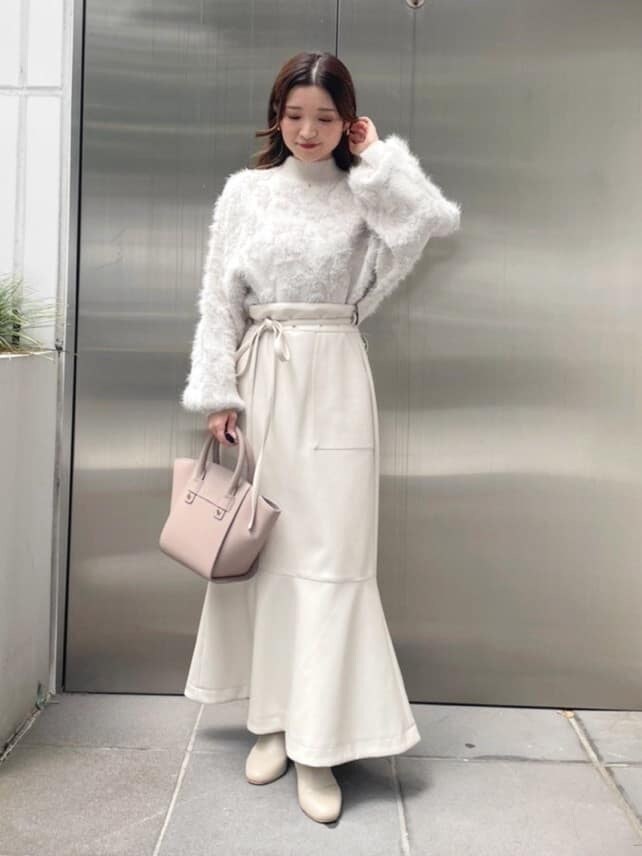 ベージュ系のハンドバッグ、ホワイト系のスカート、ホワイト系のニット/セーターを着用したレディースの秋コーディネートの3枚目の写真